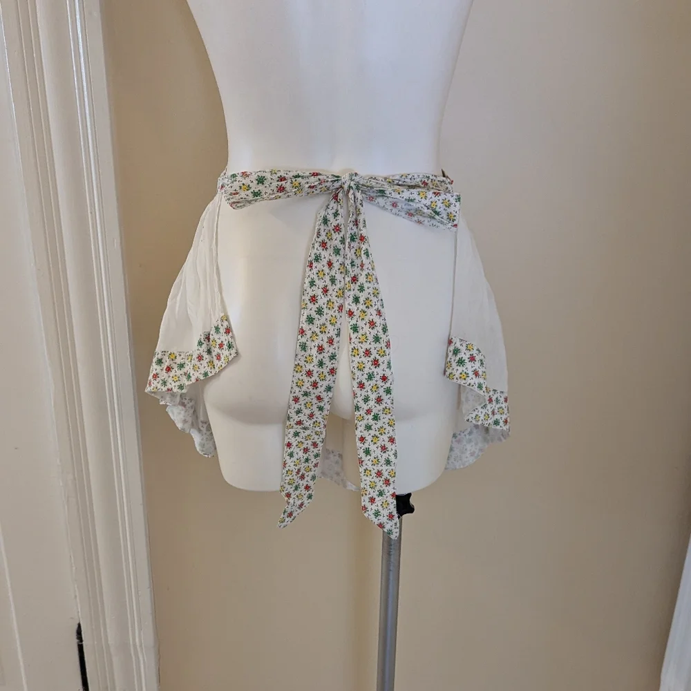 Vintage handmade white apron with red, green and red floral print.